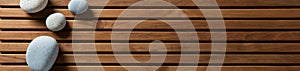 Zen pebbles set on design wooden board, top view banner