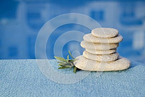 Zen pyramid of spa stones on the blurred sea background. Sand on a beach. Sea shores. Water waves texture. Left side of photo. Pla