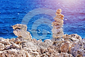 Zen pyramid of stacked rough stones on blurred sea background