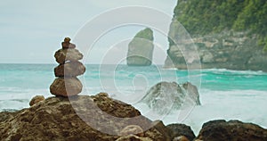 Zen Pyramid of Stones for Meditation. Rock tower balancing on beach. Seascape with ocean turquoise water, sea waves