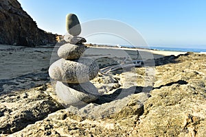 Zen rock stack on Pacific Ocean coast with waves on shore