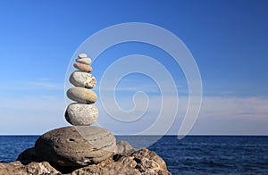 Zen rocks against the background of the sea and blue sky.