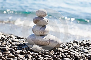 Zen sea stones pebbles stacked in a pyramid on sea coast