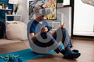 Zen senior man sitting on yoga mat in lotus position during pilates workout in living room