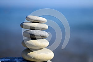 Zen spa stones with blue water and sky. Background with text space. Balance of stones.