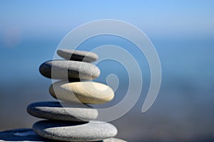 Zen spa stones with blue water and sky. Balanced stones background with copy space. Spa symbol.