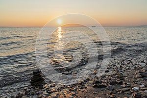 Zen stack of rocks in the sea at sunset