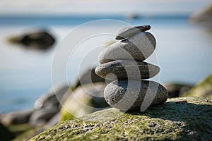 Zen stone pyramide with blurred sea shore background. Stack of balancing pebbles on the beach. Beauty, nature, meditation, harmony