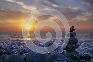 Zen stone sculpture - pebble - and calm sea at sunset