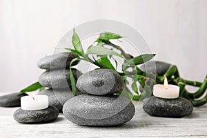 Zen stones, bamboo and lighted candles on table