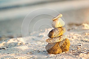 Zen Stones on beach for perfect meditation. Calm zen meditate background with rock pyramid on sand beach symbolizing stability, ha