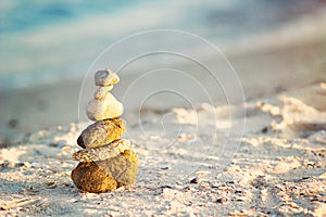 Zen Stones on beach for perfect meditation. Calm zen meditate background with rock pyramid on sand beach symbolizing stability, ha