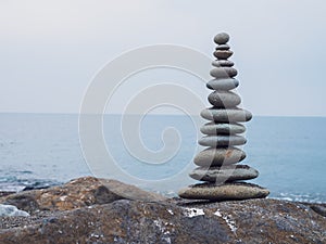 Zen stones on the beach piled by a tower
