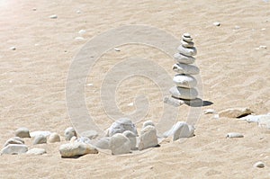 Zen stones on a beach sand. Sea pebbles tower. Harmony and stability concept.