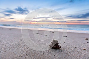 Zen stones on calm beach at sunset