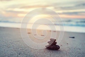 Zen stones on calm beach at sunset