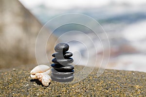 Zen stones jy on the sandy beach near the sea.