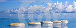 Zen stones row from large to small  in water with blue sky. 3d illustration