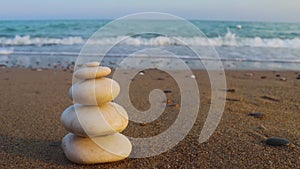 Zen stones and sea waves. The concept of harmony, stability, life balance, relaxation and meditation. A pyramid of stones on the s