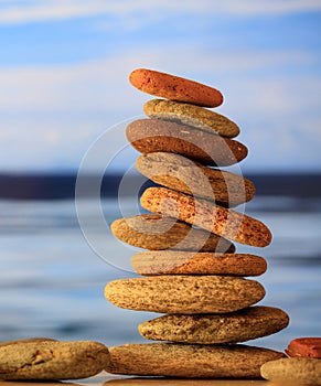 Zen stones stack on blue sky and sea background