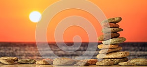 Zen stones stack on sea background at sunset