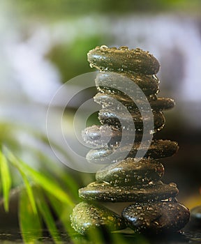 Zen stones with water drops stacked on abstract background