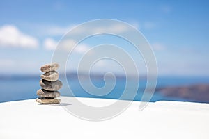 Zen stones on white background. Sunny blue sky and sea view, tranquil relax calming closeup