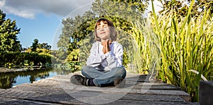 Zen young yoga child meditating alone to breathe near water