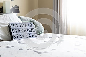 Zenithal picture of a light box with a message with a sofa behind. Coronavirus advise.Keep calm message.Stay home photo