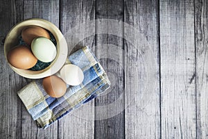 Zenithal plan eggs in wooden bowl and blue cloth, with copy space photo