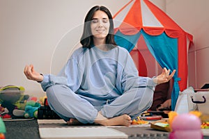 Carefree Mother Sitting in Lotus Position Surrounded by Toys photo