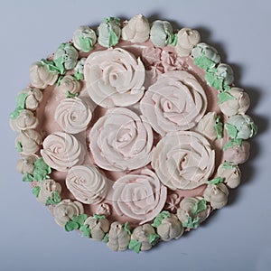 Zephyr bouquet. Marshmallow tulips are collected in a bouquet and wrapped in paper. There are zephyr roses on the table