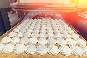 Zephyr or marshmallows on tray in production line machine. Cookie production, toned