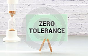 ZERO TOLERANCE text on a paper clipboard with chart and notebook on withe background