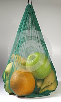 Zero waste concept. Modern shopping textile bag with fresh fruits isolated on a white background.