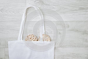 Zero waste concept. White cotton bag and two diet loaves gray wooden boards