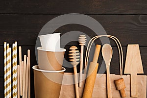 Zero waste concept with wooden utensile and paper cups and bag on wooden background with copy space photo