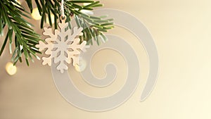 Zero waste and eco friendly christmas concept. Wooden snowflake on a Christmas tree branch on background of wooden wall