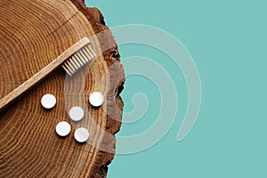 Zero waste flat lay. Bamboo toothbrush, toothpaste tablets on wooden background.