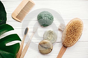 Zero waste flat lay. Natural solid shampoo bar, bamboo toothbrushes, wooden brush, deodorant cream and konjaku sponge on white w