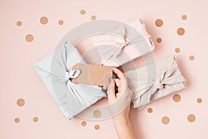 Zero waste gift wrapping traditional Japanese furoshiki style over pink background