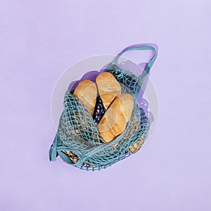 Zero-waste grocery shopping concept: bread loaves in a mesh produce bag