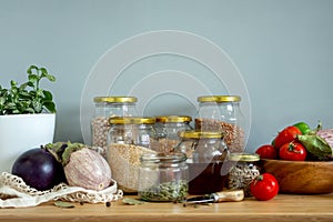 Zero waste healthy food-cereals, seeds, vegetables flat lay on grey background. Groceries in textile bags,glass jars