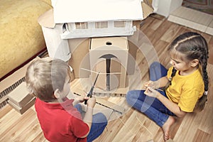 Zero waste home activity. Kids doing paper house with cardboard box, creatively thinking concept