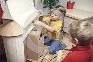 Zero waste home activity. Kids doing paper house with cardboard box, creatively thinking concept