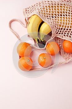 Zero waste, plastic free recycled textile produce bag for carrying fruit or vegetables on pink background. Recycle closeup,