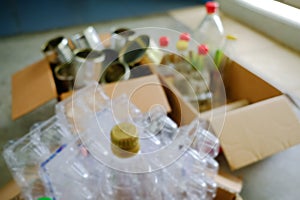 _Zero waste sustainability concept. Defocused shot of carton boxes sorting glass plastic bottles metal containers for recycling