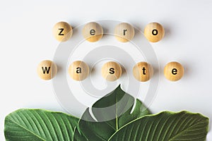 Zero waste word on wood block with green leaf on white table,eco friendly and plastic free concept