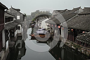 ZHOUZHUANG, CHINA: Old houses and boat reflection in a village canal