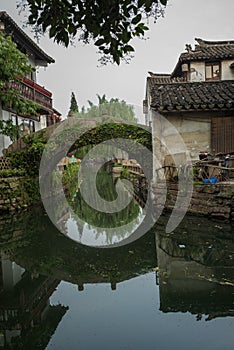 ZHOUZHUANG, CHINA: Old houses and bridge reflection in a village canal